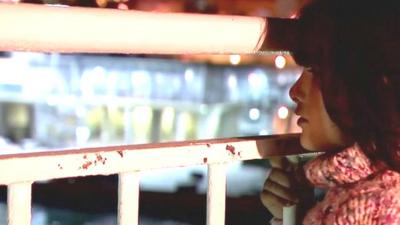 Migrant girl looks through railings