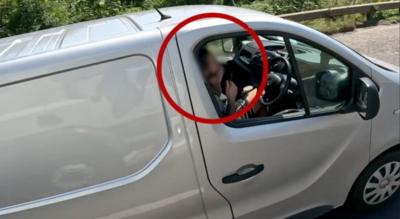 Man trimming his beard while driving on motorway