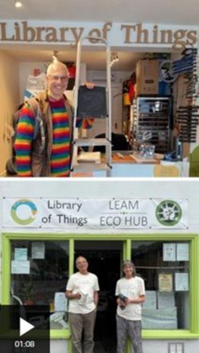 A man and woman in white t-shirts stood outside a shop with lime green window frames. The sign above the shop reads Library of Things and Leam Eco Hub