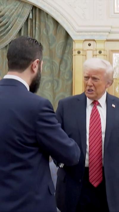 Donald Trump and Ahmed al-Sharaa shake hands