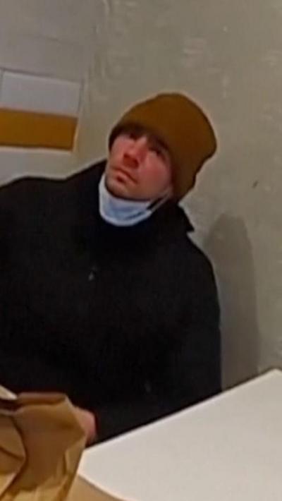Luigi Mangione in McDonald's wearing a brown beanie and facemask.