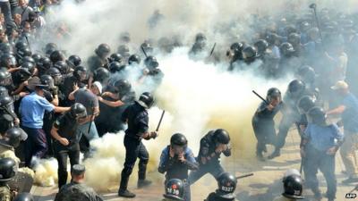 Smoke rises near the parliament building in Kiev as activists clash with police officers