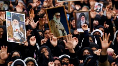 Crowd holds pictures of Iran supreme leader Ayatollah Ali Khamenei