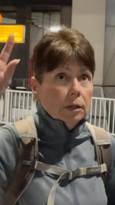 A woman with short dark hear in airport arrivals hall