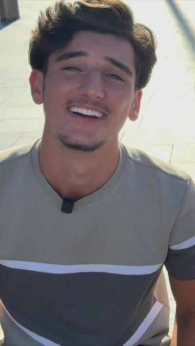 A smiling young man in a grey t-shirt