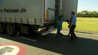 Ed Thomas approaches a man who seems to be trying to board a lorry