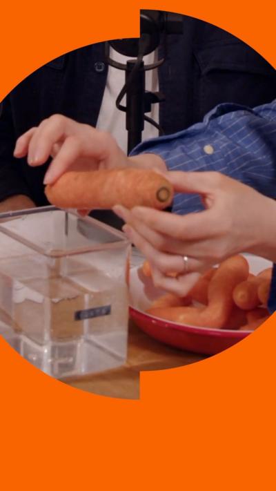 A carrot being held above a container of water