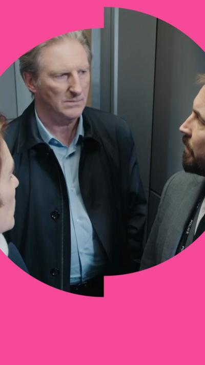 Three people stand in a lift and look at each other with serious expressions