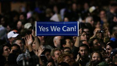 An Obama supporter holds up a sign which reads 'Yes we can' during his victory speech in Chicago