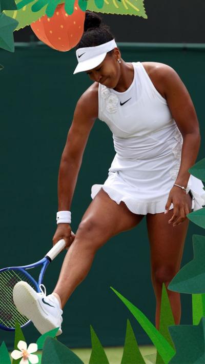 Naomi Osaka smiles and holds racket 