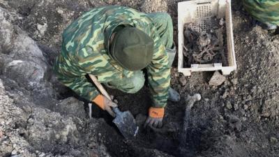 Digger at Brest grave site