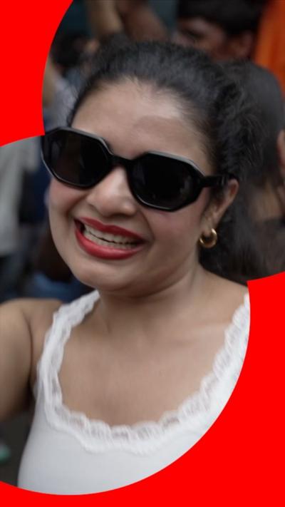 A young woman in sunglasses and a white vest