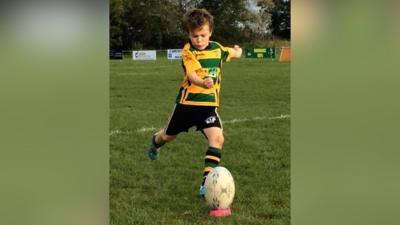 Seven-year-old Oscar kicking rugby ball