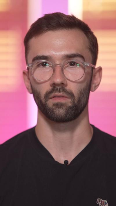 A man with glasses and dark hair, wearing a black t shirt