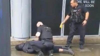 Man on the ground with two police officers