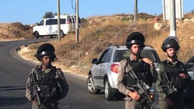 Israeli troops stand guard where the body of a 19-year-old soldier was found in the West Bank