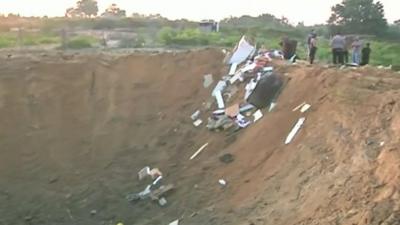 The hole left after a house was flattened by Israeli airstrikes