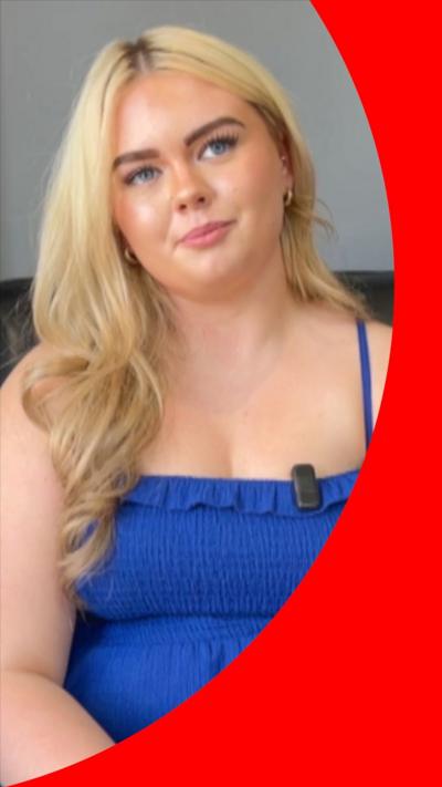 A young woman with blonde hair is sitting with her head tilted to one side. She is wearing a blue summer dress.