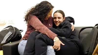 Romi Gonen hugs her mother, Meirav, on a sofa after her release