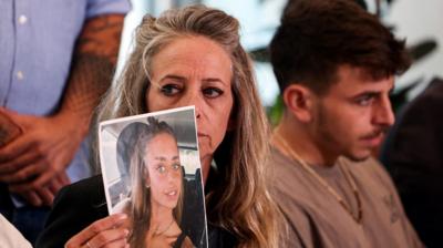 The mother of Mia Schem holds up a picture of her daughter who was kidnapped into the Gaza Strip