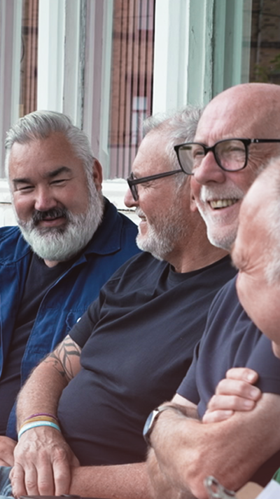 A group of men sit next to each other wearing navy