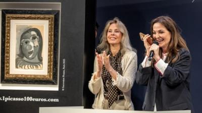 Two auctioneers stand next to a Picasso painting
