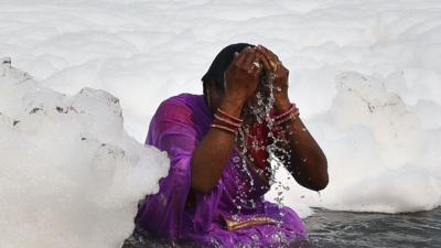 A woman bathes in the Yamuna river