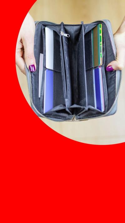 Someone with purple nails opening a wallet.