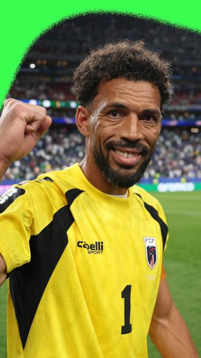 Cape Verde goalkeeper Vozinha celebrating his team progressing to the World Cup knockouts. He is wearing a yellow Cape Verde goalkeeper kit.