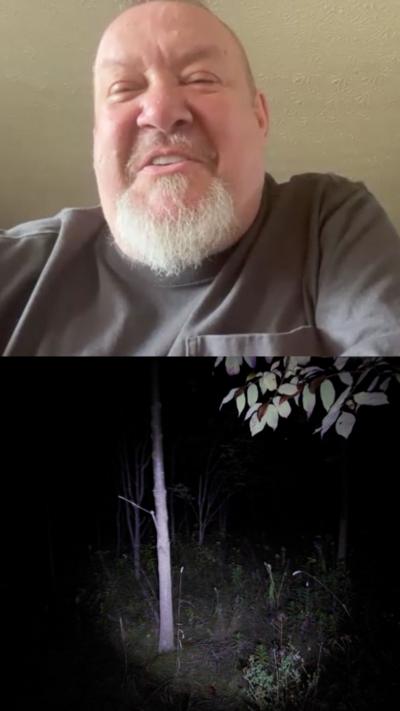 Composite image. On the top is a man with a bald head and a white beard and he is laughing. Under is an image of a woods in the dark with a torch shining out.