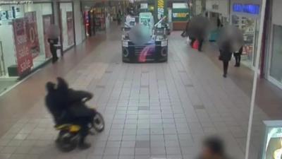 Motorbike driving through shopping centre