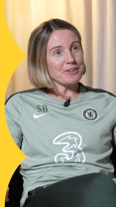 Sonia Bompastor wearing a pale green long sleeved top, sitting in chair.
