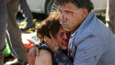 An injured man hugs an injured woman