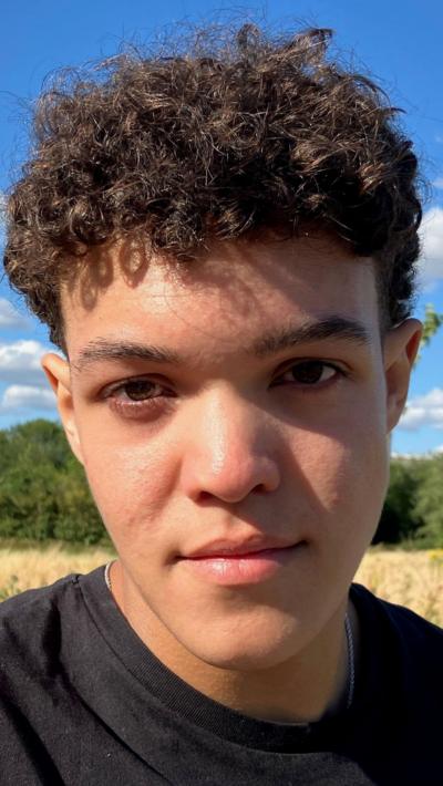 Teenager in a black t-shirt with black curly hair