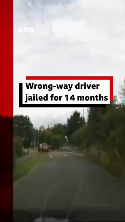 Road with caption saying wrong-way driver jailed for 14 months