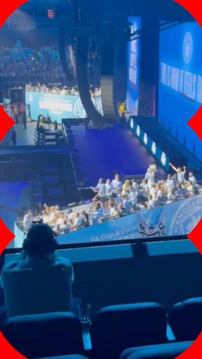 The city open-top bus is in the Co-op Live arena , it is in the blue and white City branding and has players stood on top waving to the crowd.
