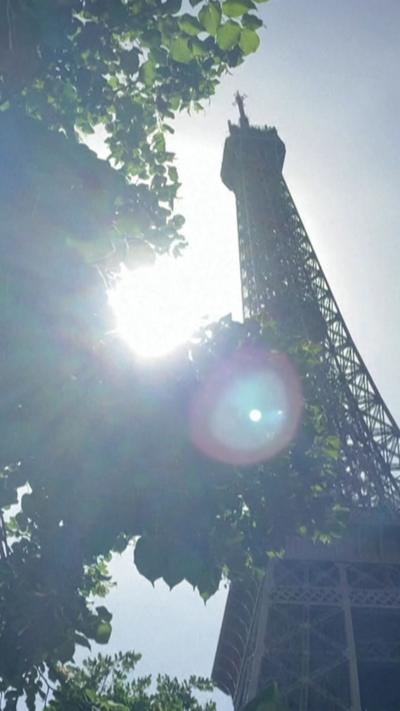 The sun behind the Eiffel Tower