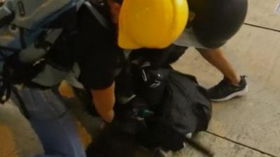 Hong Kong police arrest a protester with the help of a suspected undercover officer