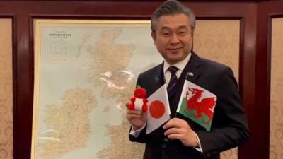 Japanese Ambassador is seen holding the Welsh and Japanese flags