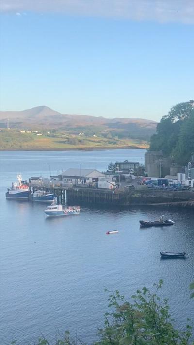 Port town with boats in the water and hill behind