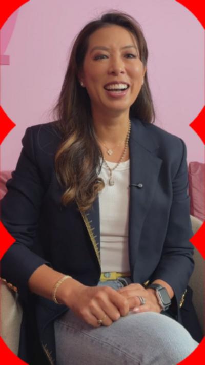The co-founder of Little Moons, Vivien Wong smiles. She wears a blue blazer and jeans and has long, straight brown hair.