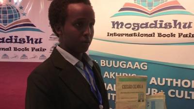 16-year-old Somali author Abukar Abdullahi Mohamed holding some of his books at the Mogadishu International Book Fair