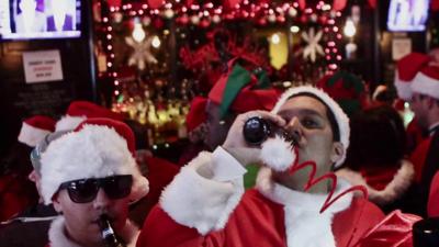 Workers dressed as as Santa drinking