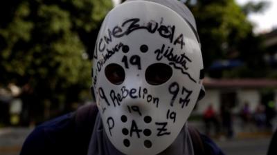 A demonstrator wears a mask during rally against Venezuela"s President Nicolas Maduro in Caracas on 24 April, 2017