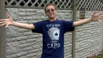 Thomas-a-boy-with-Tourette-syndrome-stands-in-front-of-the-camera-with-his-arms-stretched-out