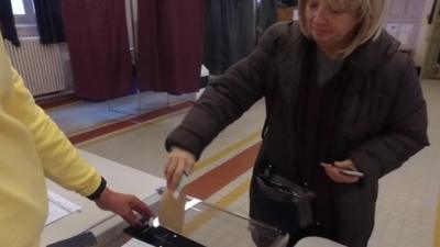 Woman casts her ballot in Paris in vote to decide the centre-right presidential candidate in next year's election