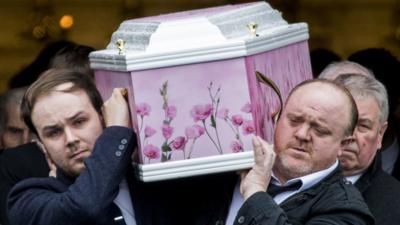 Two men carry Lauren Bullock's coffin