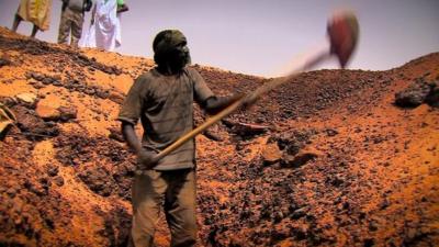 A man digging for gold in the Sahara desert in Mauritania