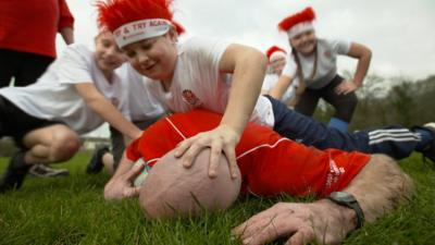 Tom Shanklin gets floored by children while playing rugby