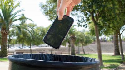 Someone throwing a smartphone into a bin